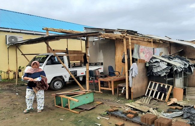 Kusniyah, 39, di depan rumahnya yang rusak setelah diterpa hujan angin Senin malam lalu hujan angin, puting beliung, rumah roboh, pura roboh, toko roboh, bpbd klungkung, dampak hujan angin