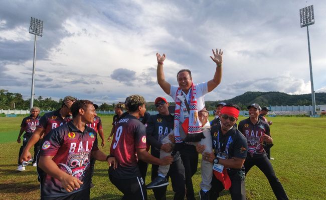 Para pemain Tim Kriket Putra PON Bali menggendong Manajer Tim Kriket PON Bali sekaligus Ketum Pengprov PCI Bali usai berhasil mengalahkan Papua di final yang berlangsung, Senin (4/10). kriket bali, emas, kawinkan emas, PON, Bali, Papua,