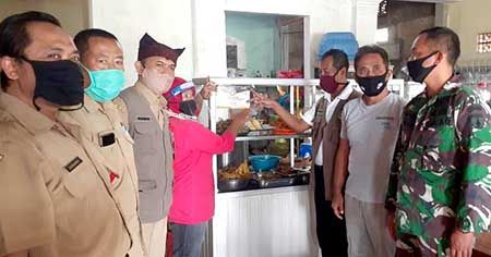 JAMIN KEAMANAN: Petugas gabungan menempelkan stiker sertifikasi protokol kesehatan di warung makan milik warga JAMIN KEAMANAN: Petugas gabungan menempelkan stiker sertifikasi protokol kesehatan di warung makan milik warga