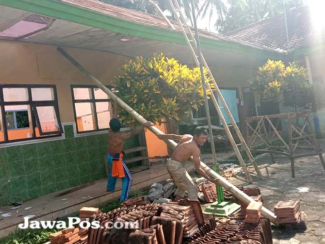 BARU LIMA TAHUN: Warga Desa Telemung, Kecamatan Kalipuro, membersihkan puing atap bangunan kelas yang runtuh. BARU LIMA TAHUN: Warga Desa Telemung, Kecamatan Kalipuro, membersihkan puing atap bangunan kelas yang runtuh.