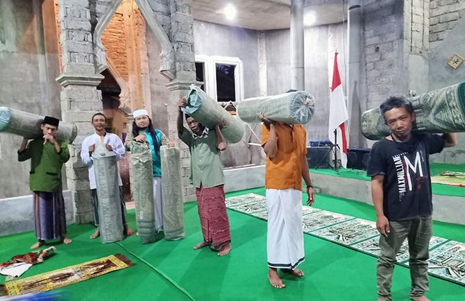 BANTU KARPET: Santri Gus Nur memikul karpet hasil sumbangan Papi Juan untuk keperluan Masjid Al Ijabah. BANTU KARPET: Santri Gus Nur memikul karpet hasil sumbangan Papi Juan untuk keperluan Masjid Al Ijabah.