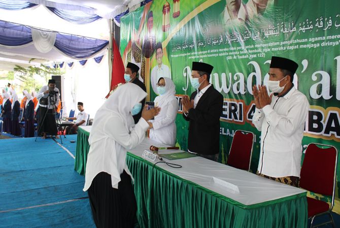 TIDAK BERJABAT TANGAN: Santri yang naik ke podium menghindari jabat tangan dengan guru. TIDAK BERJABAT TANGAN: Santri yang naik ke podium menghindari jabat tangan dengan guru.
