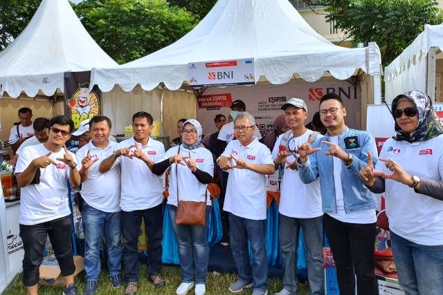 KOMPAK: Pemimpin BNI Cabang Kediri Yari Yudho Purwanto bersama karyawan di acara puncak Pekan QRIS Nasional di Lapangan GOR Jayabaya