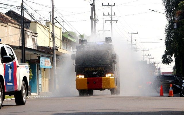 MELAJU : Mobil water canon milik Polres Kediri Kota menyemprotkan disinfektan di Jalan Dhoho, kemarin pagi. korona