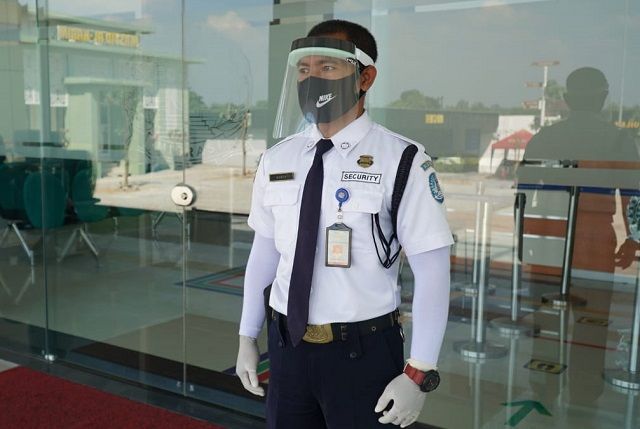 PAKAI PELINDUNG: Satpam di Kantor Imigrasi Kediri yang mengenakan faceshield. imigrasi