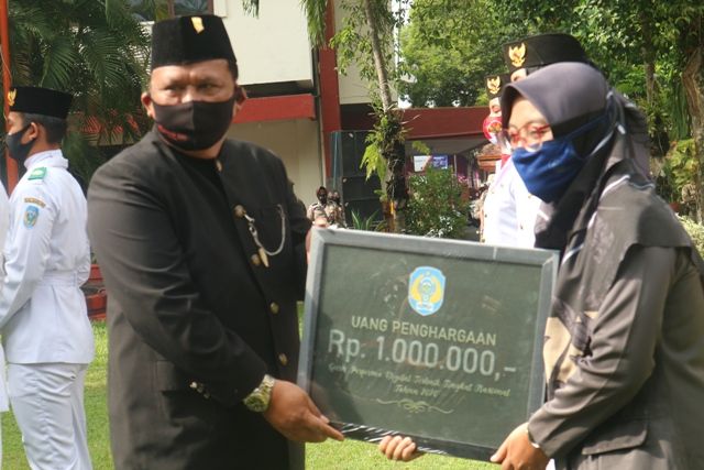 APRESIASI: Wabup Marhaen Djumadi menyerahkan penghargaan kepada guru berprestasi tingkat nasional usai upacara peringatan HUT ke-75 Pemprov Jatim kemarin. Up