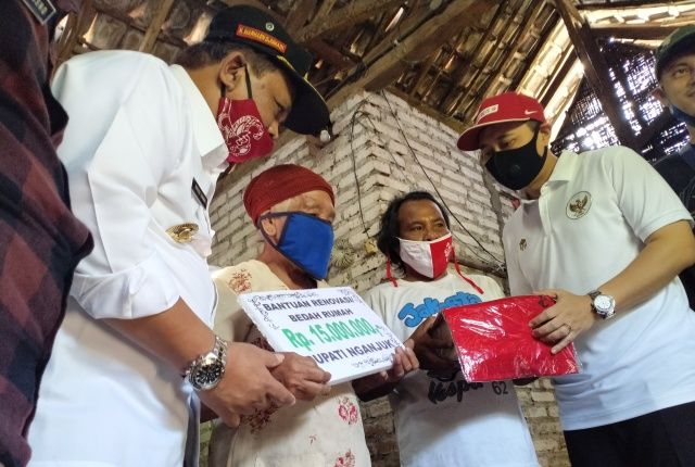 RINGANKAN BEBAN: Mas Novi (kanan) menyerahkan bantuan uang bedah rumah kepada Mbah Sukirah, warga Desa Kemaduh, Baron didampingi Wabup Marhaen (kiri). Bupati