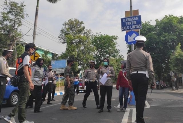 BUTUH PERBAIKAN: Tim Polda Jatim mengecek kondisi rambu-rambu di dekat SMAN 2 Nganjuk kemarin. KTL
