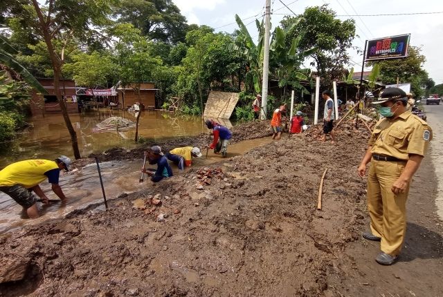 DARURAT: Camat Ngronggot M. Makrup mengecek warga yang gotong royong membersihkan saluran air di Desa Cengkok, Prambon. Pembersihan terhambat karena ada banyak titik yang tertutup bangunan permanen. Gotong Royong