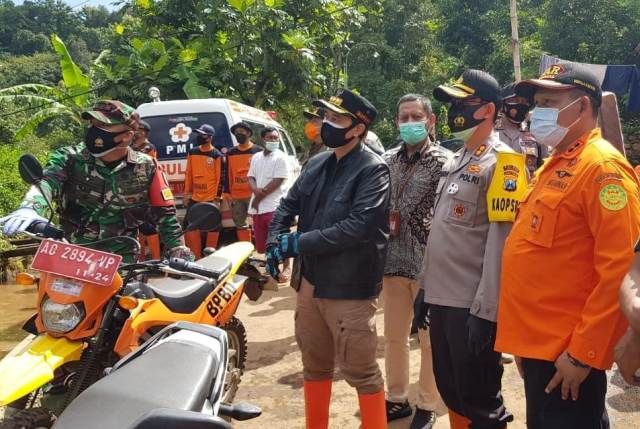 CEK LAPANGAN: Pinca Bank Jatim Nganjuk Teguh Sunyoto (baju batik) menyaksikan proses evakuasi korban longsor di Dusun Selopuro, Desa/Kecamatan Ngetos kemarin. Baksos