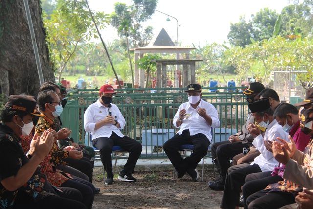 KHUSYUK: Bupati Novi (topi merah) memimpin doa bersama Wabup Marhaen (kemeja putih, kanan) saat berziarah di makam Marsinah jelang peringatan Hari Buruh besok. Bup