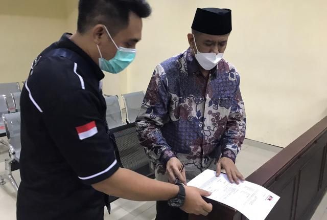 ADMINISTRASI: Taufiq menyerahkan kembali berkas yang ditandatangani usai persidangan kemarin. Sidang