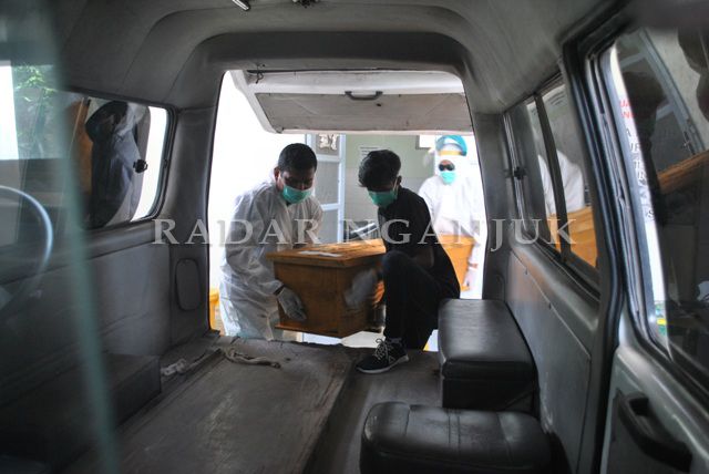 BERAT: Sopir Ambulans RSUD Nganjuk mengangkat peti jenazah ke ambulans. Berat