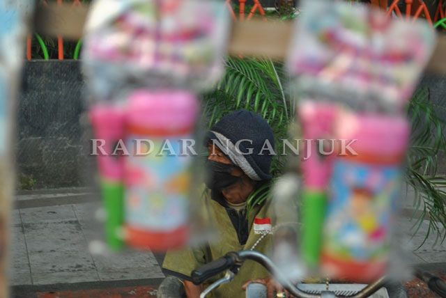 TUNGGU PEMBELI: Penjual mainan berharap pengunjung Alun-Alun Nganjuk kembali ramai. PKL
