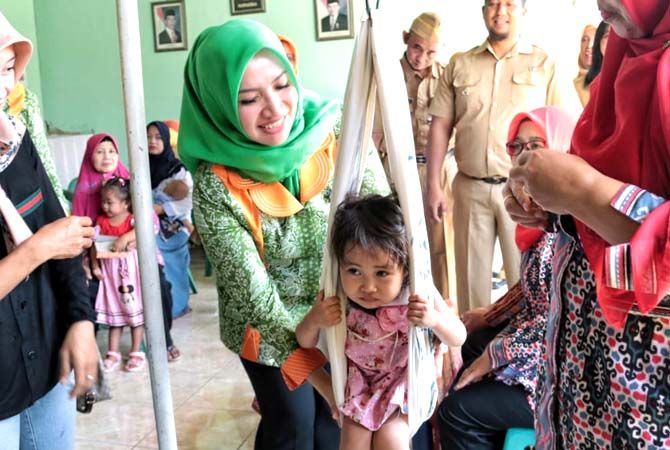 TIMBANG ANAK: Mawar Hartopo menimbang anak di posyandu. TIMBANG ANAK: Mawar Hartopo menimbang anak di posyandu.