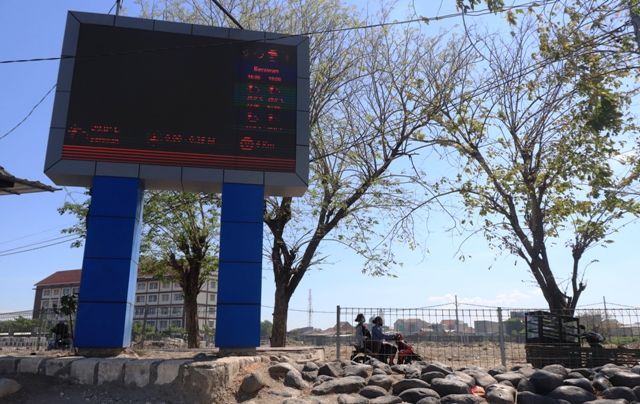 ANTISIPASI: Pengendara motor melintas tak jauh dari perangkat Elektronic Weather Display (EWD) di kawasan Kedung Cowek, Surabaya. ANTISIPASI: Pengendara motor melintas tak jauh dari perangkat Elektronic Weather Display (EWD) di kawasan Kedung Cowek, Surabaya.