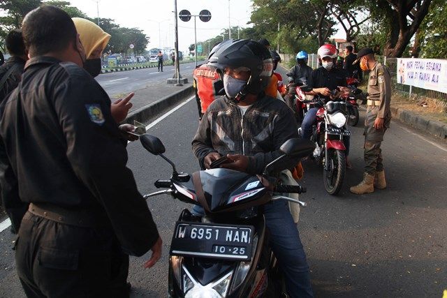 PENYEKATAN: Petugas memeriksa kelengkapan dokumen pengendara yang melintasi Jembatan Suramadu di Tambak Wedi, Surabaya, Senin (7/6). PENYEKATAN: Petugas memeriksa kelengkapan dokumen pengendara yang melintasi Jembatan Suramadu di Tambak Wedi, Surabaya, Senin (7/6).