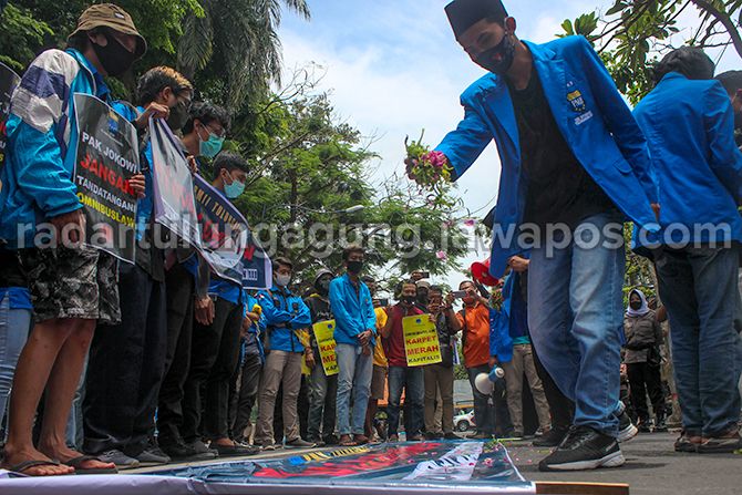 ASPIRASI: Salah satu kader PMII Tulungagung tengah menaburkan bunga setaman di atas banner bertuliskan menolak ombdibus law UU Cipta Kerja di depan gedung DRPD Tulungagung. ASPIRASI: Salah satu kader PMII Tulungagung tengah menaburkan bunga setaman di atas banner bertuliskan menolak ombdibus law UU Cipta Kerja di depan gedung DRPD Tulungagung.